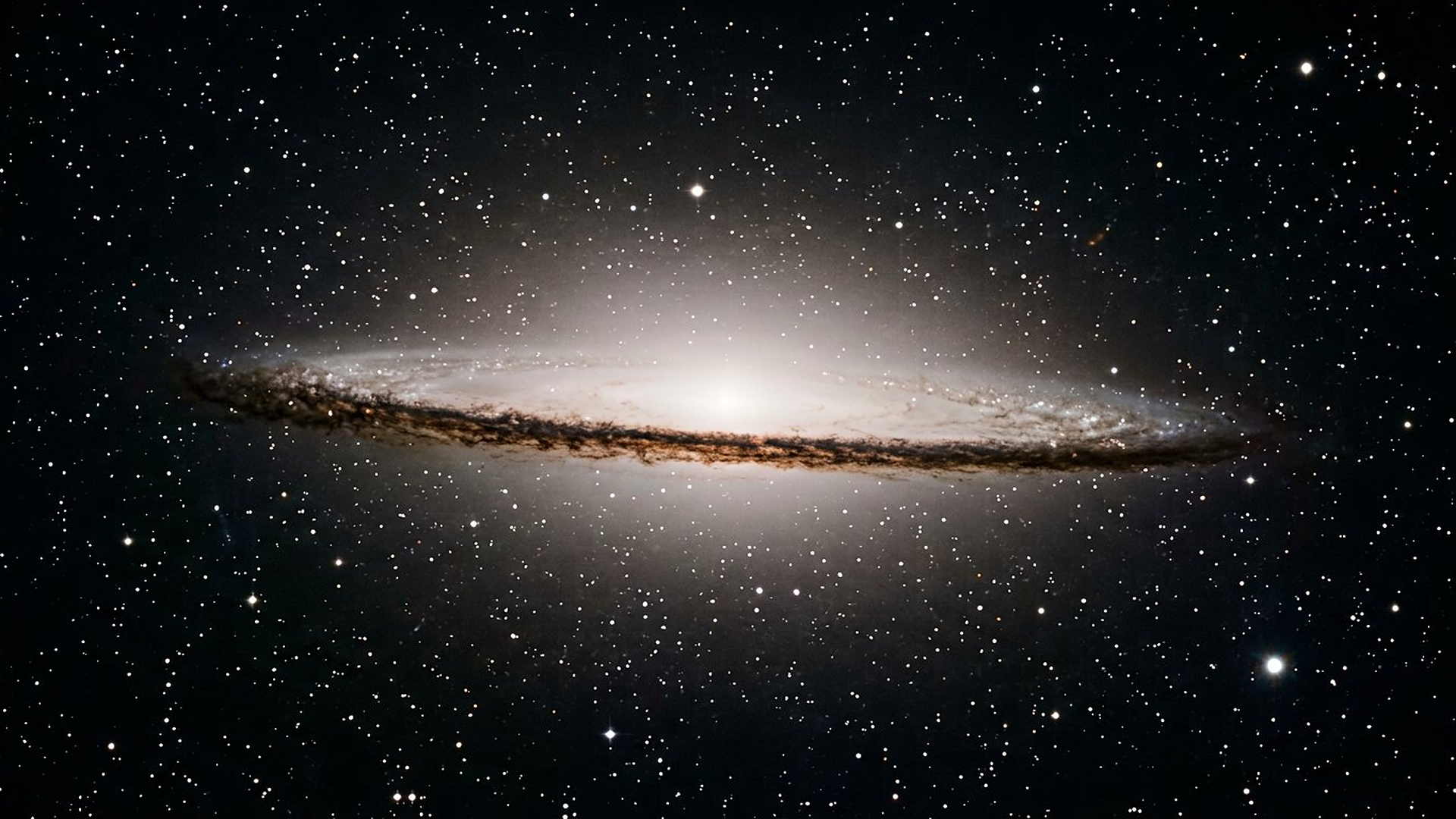 Une galaxie de profil et son cortège de poussière : la même physique, à trois cent mille années-lumière de distance.